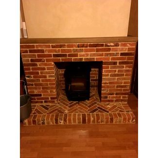 We built the brick fireplace using reclaimed bricks and lime mortar to sit this stove in