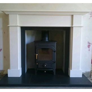 Clearview Pioneer 400 on 4 legs with brass fittings sitting in a Limestone mantel with a honed granite hearth and slips