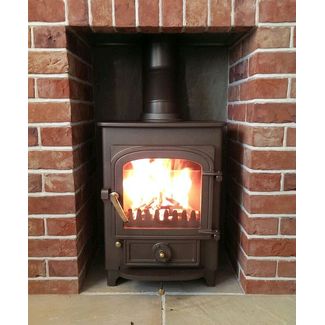 Clearview Pioneer 400 on 2 legs in honey glow brown with brass fittings in a brick fireplace