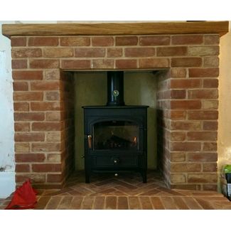 Clearview Vision 500 8kw stove on 4 inch legs in a brick fireplace we built and an oak shelf