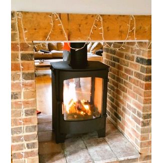 Double sided stove in a brick fireplace with beam