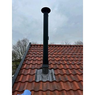 Black T W Pro chimney system through a clay pantile roof