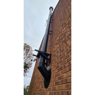 Black T W PRO flue up the side of the house