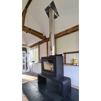 Di Lusso R6 CUBE woodburner on a bench with a stainless steel polished chimney flue