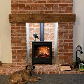 Heta Ambition 8 woodburner in a soft red reclaimed brick chimney breast we built