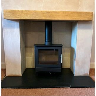 Heta Inspire 45 multi-fuel 5kw stove with a Smooth pale oak effect deep beam and Corinthian stone chamber set