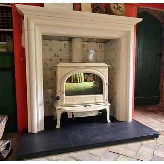 Jotul F400 in ivory enamel woodburning stove with Aegean limestone mantel, tiled recess and riven slate hearth