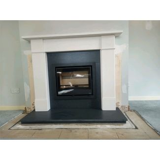 Pevex Serenity inset woodburner with 4 sided frame in a stone fireplace surround