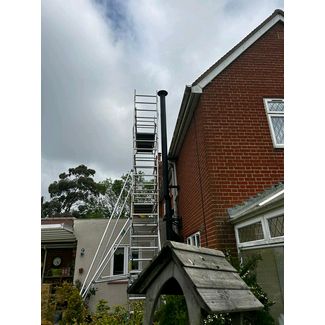 Tower scaffolding erected to install a black twin wall flue system