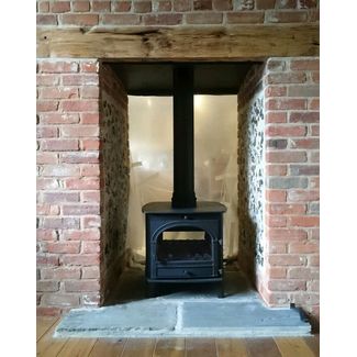Double sided Hunter Herald 14 multifuel stove in a double sided fireplace we built out of brick and flint.