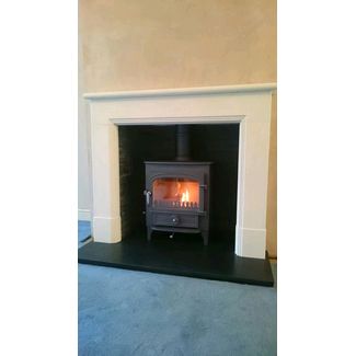 Clearview Vision 500 8kw multifuel stove with a Hanwell Aegean limestone mantel
