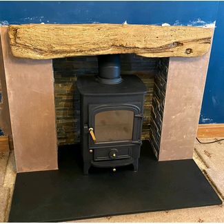 Clearview Pioneer 400 5kw mutlifuel stove with a rusty slate chamber set and a York non-combustible beam with riven slate hearth
