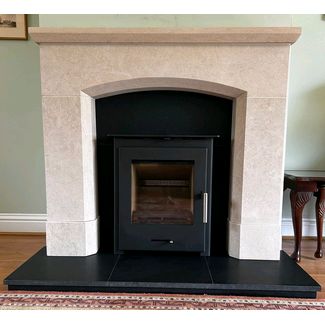 Pevex 60 inset convector stove in a Corinthian stone fireplace and honed granite hearth